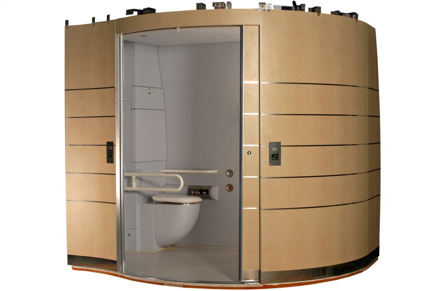 Eine komplette Semvac-Toilettenkabine mit geöffneter Tür in der Werkhalle; im Inneren sind das Waschbecken und die Toilette zu sehen.